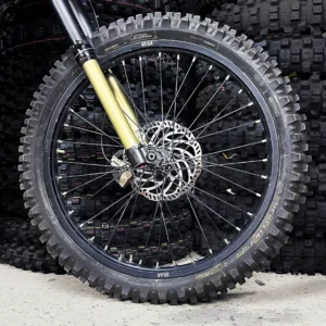 The 19” front wheel is mounted on a Surron e-bike with OFF-ROAD tires.