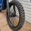 The 18" front wheel is mounted on a Surron e-bike with OFF-ROAD tires.