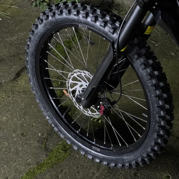 La roue avant de 21 pouces est montée sur un vélo électrique Talaria avec des pneus OFF-ROAD.